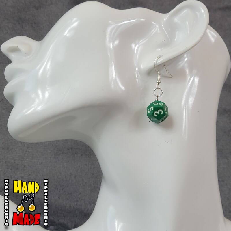 A pair of plastic green 12-sided dice charms, hanging from a silver French hook, displayed on a white mannequin head.