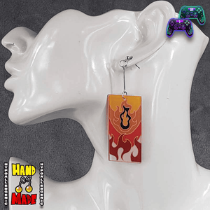 Pair of flame-themed acrylic Hanafuda earrings with bold red and orange design, displayed on a white molded earring stand.