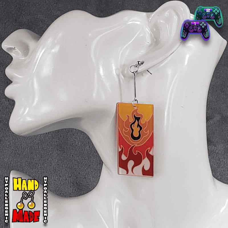 Pair of flame-themed acrylic Hanafuda earrings with bold red and orange design, displayed on a white molded earring stand.