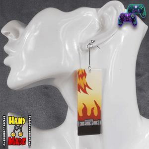 Anime earrings featuring yellow and red flames in the top left corner above a black bottom border, inspired by traditional Hanafuda cards, shown on white display.