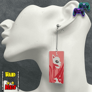 Large Acrylic Fox Mask Hanafuda Anime Earrings displayed on a white earring stand, featuring a soft salmon-colored fox mask charm on silver dropped posts.