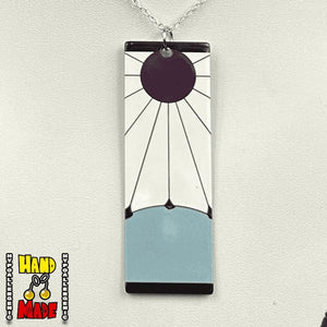 Maroon circular sun with black rays rising over a grey hill with black borders on top and bottom, paired with a sterling silver chain and silver jump ring.