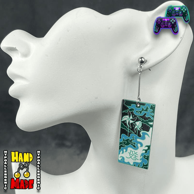 Large Acrylic Windmills Hanafuda Anime Earrings shown on a white molded stand, featuring a bold green and turquoise windmill motif with silver dropped posts.
