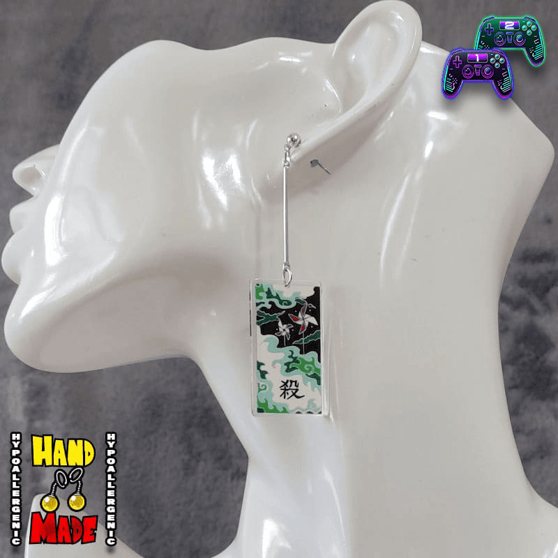 Small Acrylic Windmills Hanafuda Anime Earrings displayed on a white molded stand, featuring bright green and brown windmill motifs on silver dropped posts.