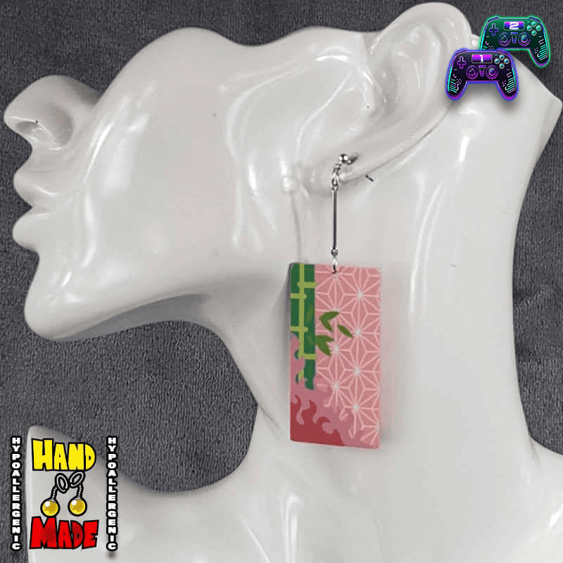 A pair of Acrylic Nezuko Hanafuda Earrings displayed on a mannequin head, featuring a colorful card design with character artwork.