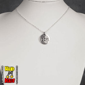 A silver necklace with a circular charm stamped with the word 'BOY!', attached to a silver chain, displayed on a mannequin torso.