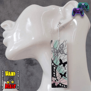 A pair of Acrylic Shinobu Hanafuda Earrings displayed on a mannequin head, featuring vibrant colors and Japanese card designs.