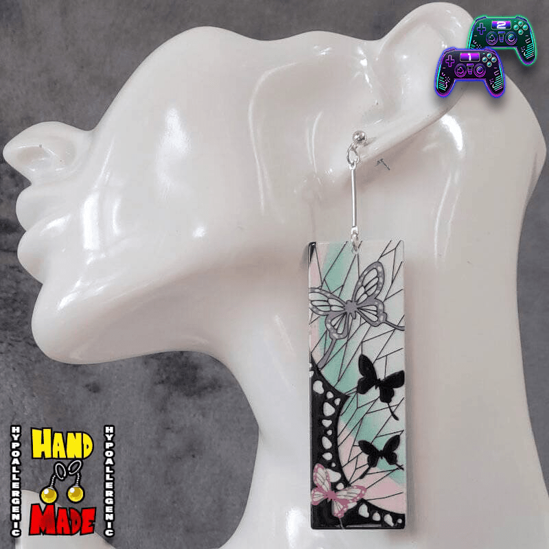 A pair of Acrylic Shinobu Hanafuda Earrings displayed on a mannequin head, featuring vibrant colors and Japanese card designs.
