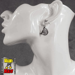 A pair of silver lute charms, hanging from a silver dropped post, displayed on a mannequin head.