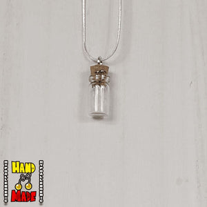 A glass jar, filled with Quartz crushed crystal, hanging from a silver necklace.