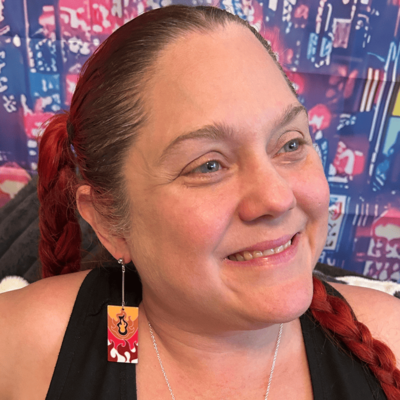 Person wearing flame-inspired acrylic anime earrings with silver dropped posts, showing bold colors and lightweight design in a casual setting.