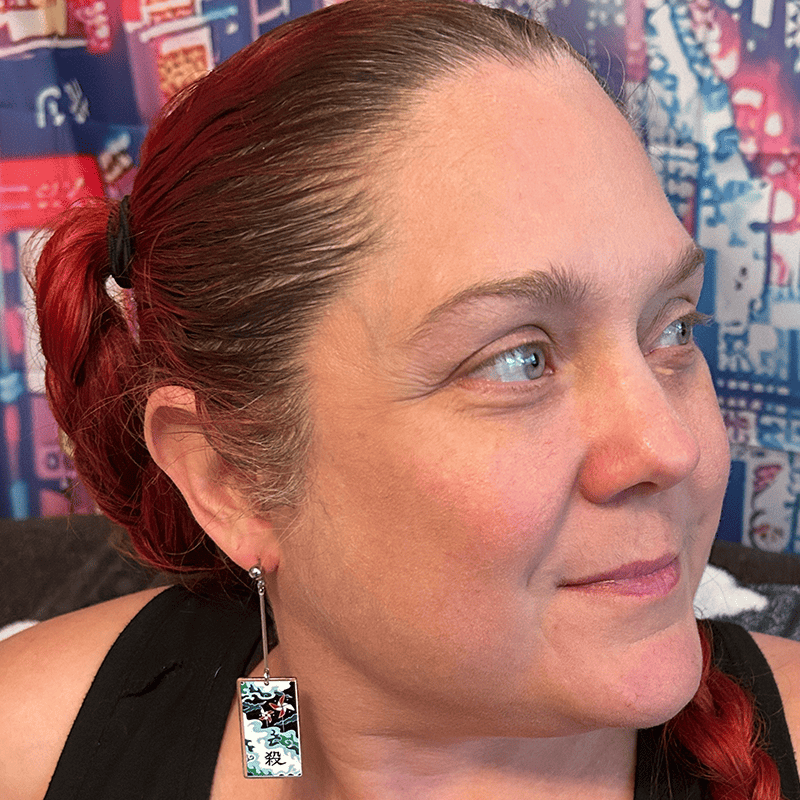 Model wearing the small Acrylic Windmills Hanafuda Anime Earrings, showcasing the vibrant green and brown windmill charm hanging from sterling silver dropped posts.