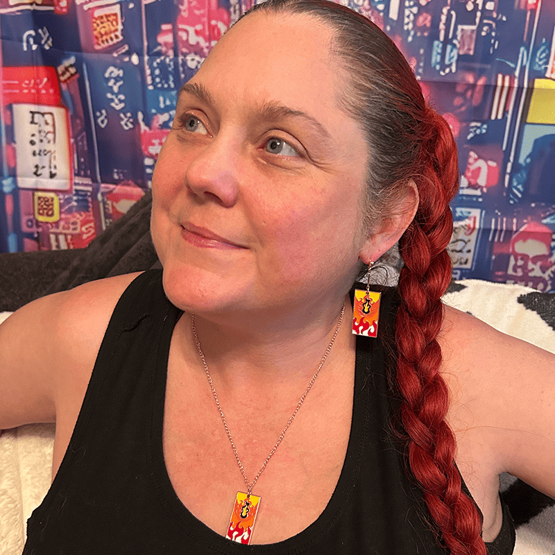 Model wearing the Metal Fire Breathing Hanafuda Anime Necklace, showing the flame design charm and silver chain resting across the chest.
