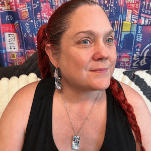 Model wearing the Metal Windmills Hanafuda Anime Necklace, showing the bold windmill design on a polished metal charm with a silver chain across the chest.