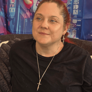 Model wearing Silver Cross Anime Necklace with polished silver cross pendant and silver chain.