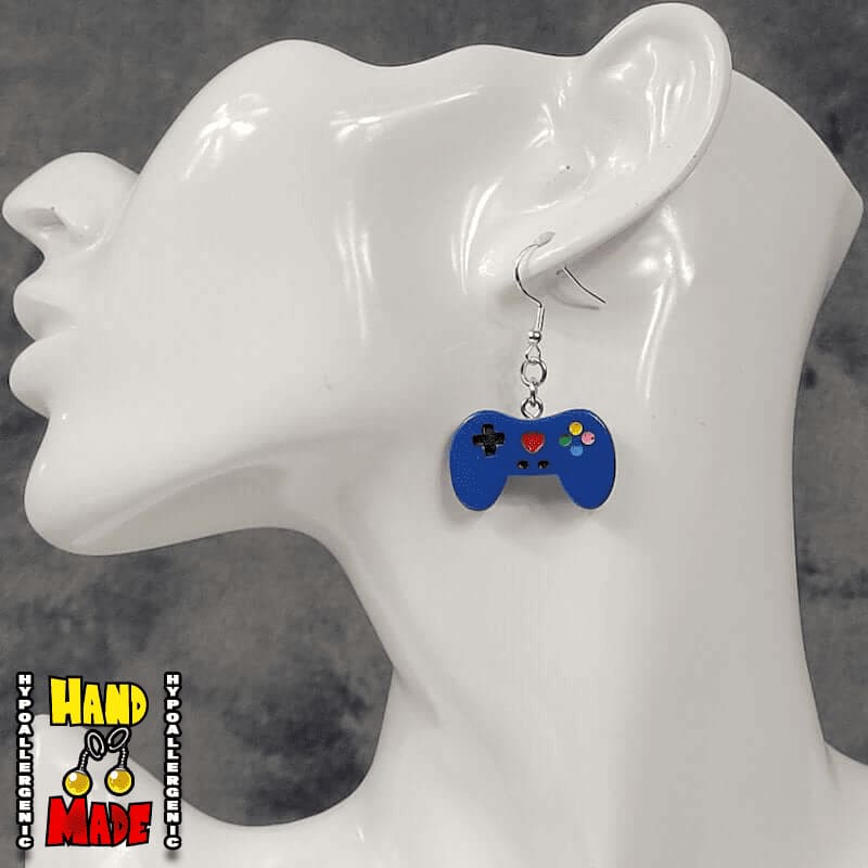 A pair of blue plastic video game controller-shaped earrings displayed on a mannequin head.
