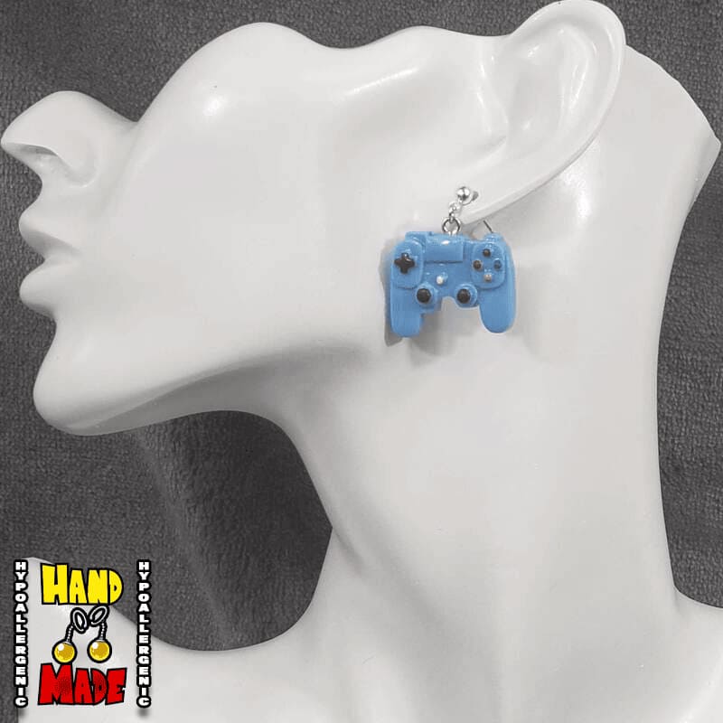 A pair of blue plastic earrings designed to resemble X-Box controllers, hanging from a silver dropped post, displayed on a mannequin head.