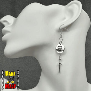 A pair of silver-colored earrings featuring a round engraved charm with the text 'Roll for Initiative' and a dangling sword charm, displayed on a mannequin ear.