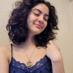 Model wearing Double Ouroboros Movie Necklace with intertwined gold and silver snake pendant on a silver chain.
