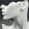 A pair of silver stud earrings featuring the Butterfly Crest design displayed on a mannequin head.
