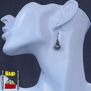 A pair of BB-8 charm earrings displayed on a mannequin head, featuring silver posts and a detailed design of the droid from the Star Wars franchise.