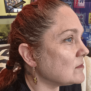 Model wearing Jeweled Gold Mask Anime Earrings with gold mask charm and jeweled dropped posts.