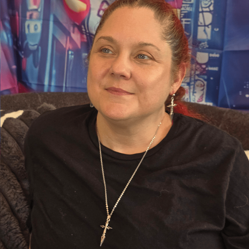 Model wearing Silver Cross Anime Necklace with polished silver cross pendant and silver chain.