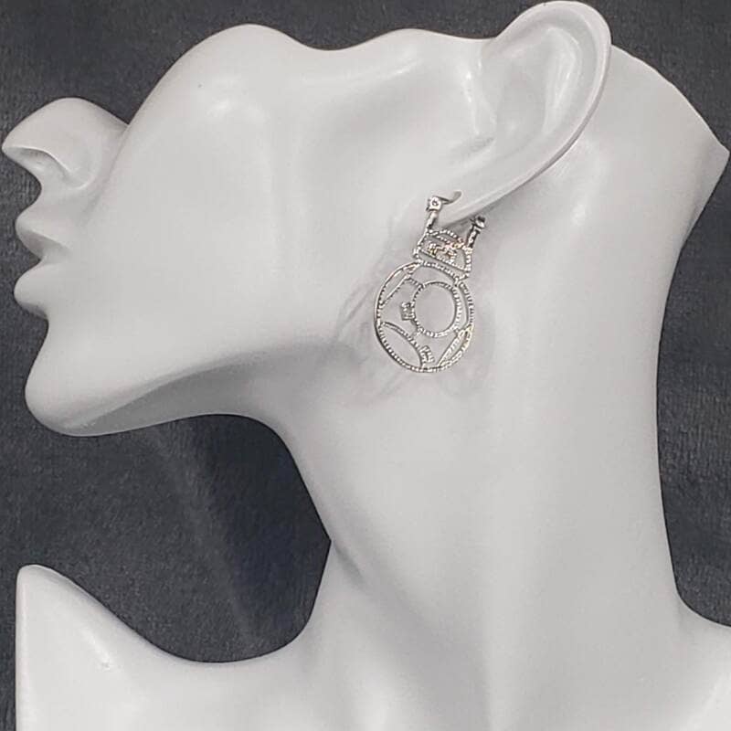 A pair of cutout BB-8 earrings displayed on a mannequin head.