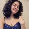 Model wearing Double Ouroboros Movie Necklace with intertwined gold and silver snake pendant on a silver chain.