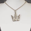 A silver-colored crown-shaped necklace on a mannequin bust, featuring a silver chain.